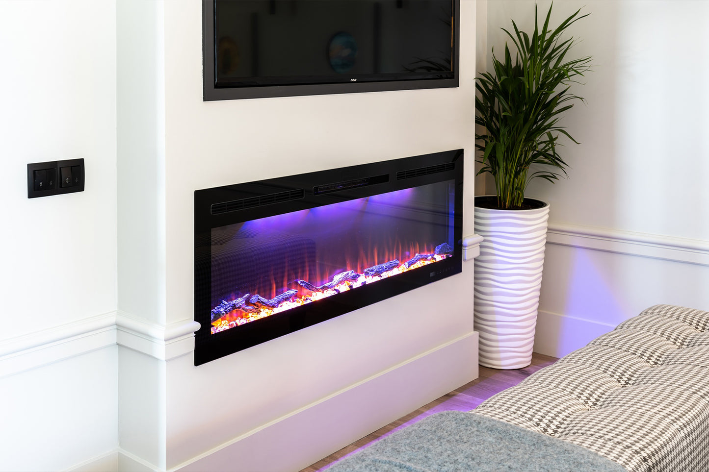 Chimenea eléctrica Mystflame Crystal 36 instalada debajo del televisor.